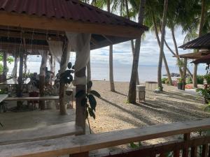 een paviljoen op het strand met de oceaan op de achtergrond bij A-House Beachfront 