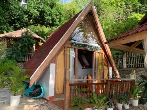 a small house with a thatched roof at A-House Beachfront 