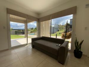 a living room with a couch and a large window at Sunset Village in Villa Carlos Paz