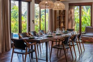 a dining room with a long table and chairs at Villa Tramonto By Le Cielo in Canggu