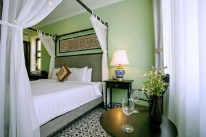um quarto com uma cama e uma mesa com copos de vinho em Hoi An Town Home Resort em Hoi An