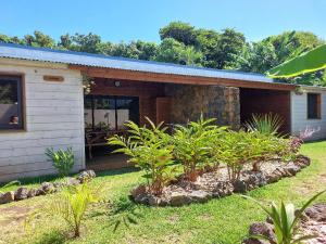 una pequeña casa con plantas delante en La Rose du Sud en Saint-Joseph