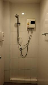 a shower in a bathroom with a hand dryer on a wall at Terminal58hostel@town in Ban Lo Long