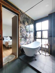 a large bathroom with a tub and a bedroom at The Willow Phangan in Ko Phangan