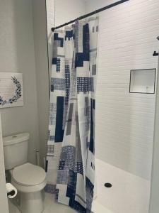 Un baño con inodoro y cortina de ducha. en Urban Sanctuary, en San Antonio