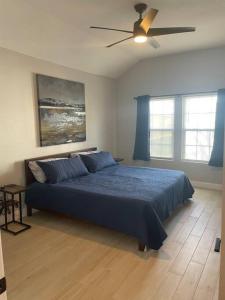 a bedroom with a blue bed and a ceiling fan at Urban Sanctuary in San Antonio