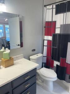 a bathroom with a toilet and a sink and a mirror at Urban Sanctuary in San Antonio