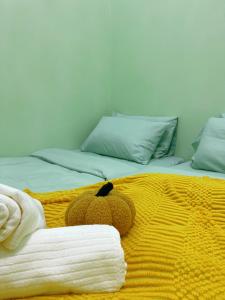 un orsacchiotto che giace sopra un letto di C & L Home 002 a Keluang