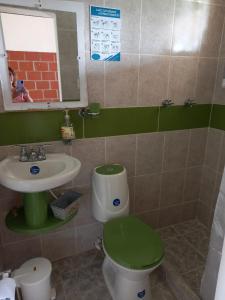a bathroom with a green toilet and a sink at LA RIVERA HOSTERIA CAMPESTRE in Villamaría