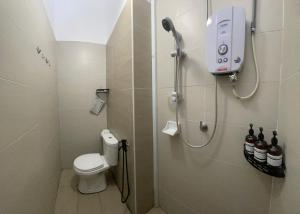 uma casa de banho com chuveiro, WC e garrafas de cerveja em C & L Home 002 em Keluang