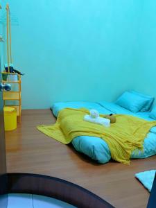 una camera con due letti e una coperta gialla di C & L Home 002 a Keluang