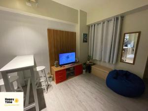una pequeña sala de estar con TV y escritorio en Affordable Vacation Rental in San Jose Del Monte Bulacan, en Tunkong Manga
