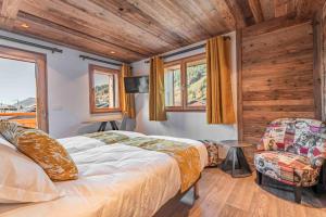 um quarto com uma cama, uma cadeira e janelas em Chalet CHARMING B AND B em Les Gets