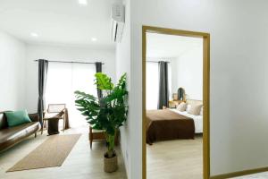 un soggiorno con specchio e letto di D village condominium a Chiang Mai