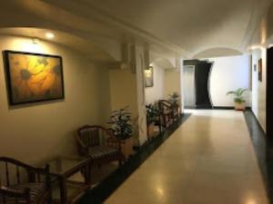 a hallway with chairs and a painting on the wall at Hotel Lawrence, Amritsar in Amritsar