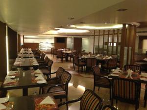 uma sala de jantar com mesas e cadeiras num restaurante em Hotel Lawrence, Amritsar em Amritsar