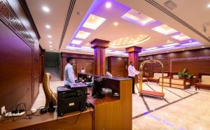Deux hommes se tiennent debout dans une pièce avec dans l'établissement RED-5 - AL Safa Suites, à Salalah