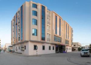 a large building with a car parked in front of it at RED-5 - AL Safa Suites in Salalah