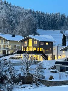 une maison en hiver avec de la neige au sol dans l'établissement place2be - exclusive apartment, à Faistenau