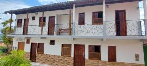 a building with wooden doors and a balcony at Mary Suítes in Lençóis