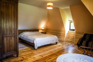 - une chambre avec un lit et une chaise dans l'établissement Osada Chytrusówka, à Baligród