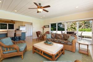 a living room with a couch and a ceiling fan at Hale Kainalu in Kailua