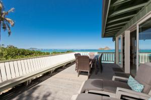 a balcony with a table and chairs and the ocean at Hale Kainalu in Kailua