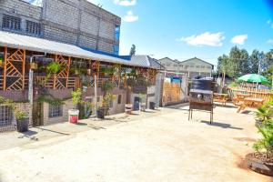 um pátio exterior com comodidades para churrascos e vasos de plantas em Four seventy em Meru