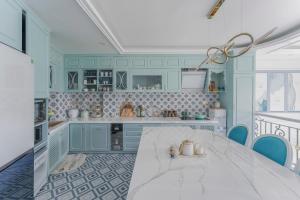a kitchen with a white table and blue cabinets at Súp Lơ House in Da Lat