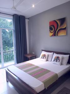 a bedroom with a large bed with a large window at kandy hill vilaa in Kandy