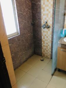 a bathroom with a shower with a tiled floor at ABP Studio's in Ghaziabad