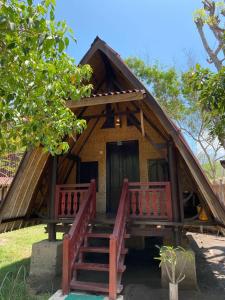a small house with a thatched roof and two decks at The Exile Sunset Trawangan in Gili Trawangan