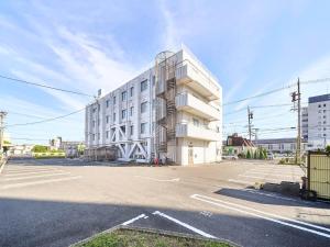 um grande edifício branco numa rua em Okasan Hotel - Vacation STAY 77675v em Ogaki