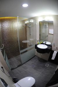 安曼的住宿－普萊姆酒店，一间带两个盥洗盆和淋浴的浴室