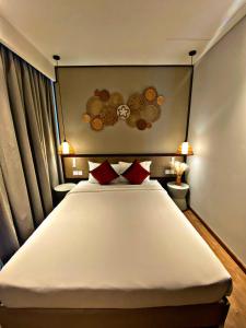 um quarto com uma grande cama branca com almofadas vermelhas em Apec Mandala Cham Bay Mui Ne 5* em Ấp Thiẹn Ái