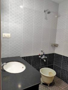 La salle de bains est pourvue d'un lavabo et de toilettes. dans l'établissement Hotel Sri Arulmuthu Residency Madurai, à Madurai