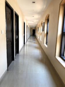 un corridoio vuoto di un edificio con lungo corridoio di Hotel Sri Arulmuthu Residency Madurai a Madurai