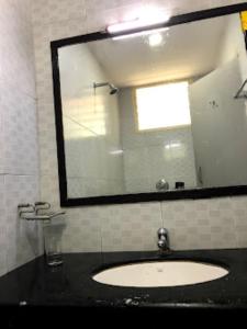 a bathroom with a sink and a mirror at Hotel Sri Arulmuthu Residency Madurai in Madurai