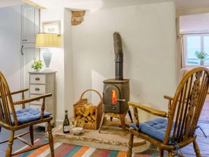 a living room with two chairs and a wood stove at 4 Bed in Monmouth 42868 in Cwmcarvan