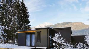 a tiny house in the snow with mountains in the background at Lodge Hochwipfel in Oberdöbernitzen