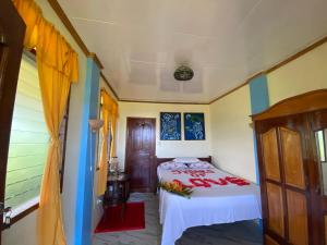 a bedroom with a bed with a red blanket at Santa Claus Hilltop in San Vicente