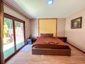 a bedroom with a bed and a large window at Good Mood Resort in Ko Lipe