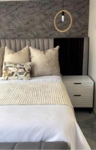 1 dormitorio con cama blanca y mesita de noche en BKT Boutique Lodge en Ga-Matsi