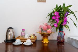uma mesa com uma cesta de frutas e um vaso com flores em The Khmer house Villas em Siem Reap