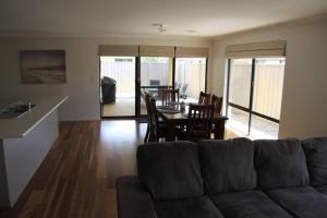a living room with a couch and a table and chairs at Southern River Family Accommodation. Free WiFi in Perth