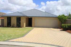 a house with a garage in front of it at Southern River Family Accommodation. Free WiFi in Perth