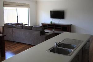 a kitchen and living room with a sink and a couch at Southern River Family Accommodation. Free WiFi in Perth