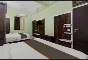 a hotel room with two beds and a closet at Hotel Shree Guest House in Sawāi Mādhopur