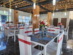 a dining room with white tables and white chairs at JADE RESORT - Bauang, La Union in Bauang