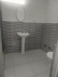 uma casa de banho com um lavatório, um espelho e um WC. em Casa de relajo em Punta Negra